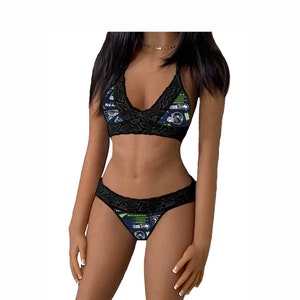 May include: Black lace lingerie set with a green and blue graphic print featuring the Seattle Seahawks logo and text. The set includes a halter top and a thong.