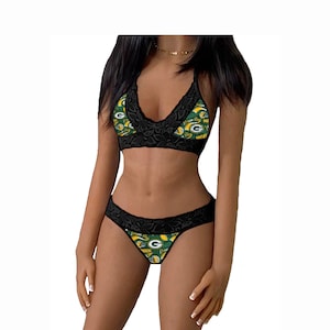 May include: Black lace lingerie set featuring a green and gold Green Bay Packers print. The bra has a halter style and the panties are a cheeky style.