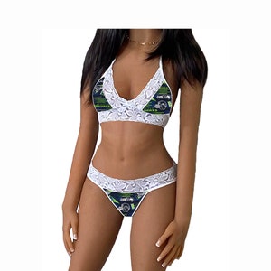 May include: White lace lingerie set with a blue and green print featuring a football helmet and the words "Seahawks" and "Hawks".