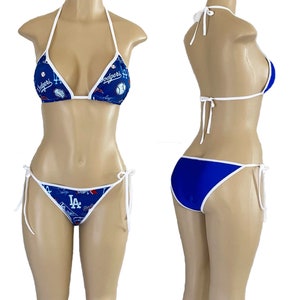 May include: A blue and white bikini with a Los Angeles Dodgers theme. The top has a white trim and the bottom has a white trim and ties on the sides.