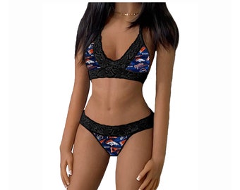 May include: Black lace lingerie set with a blue and orange print featuring a sports team logo. The bra has a halter style neckline and the panty is a cheeky style.