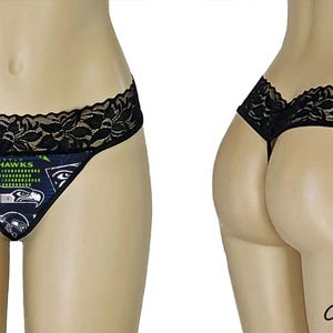 May include: Black lace g-string panty with a colorful graphic print featuring a football team logo and the words "Seahawks".