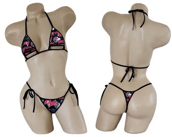May include: Black bikini with a red and white print featuring a football helmet and other sports-related graphics. The bikini top has a halter style and the bottom is a string bikini.