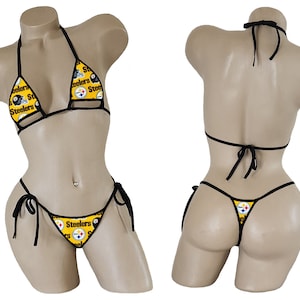 May include: A two-piece bikini set featuring the Pittsburgh Steelers logo in black and gold. The top is a halter style, and the bottoms are a thong style with tie closures. The bikini is displayed on a mannequin.