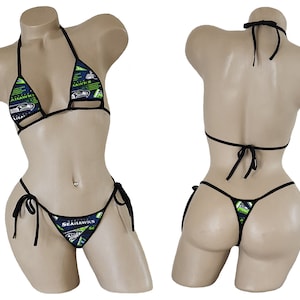 May include: Black bikini with a green, blue, and white Seattle Seahawks print. The bikini top has a halter style and the bottom is a string bikini.