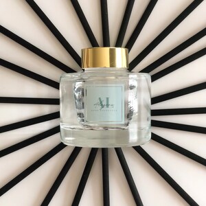 May include: A clear glass bottle with a gold lid and black diffuser sticks. The bottle has a label that says "Alley" and "Home Fragrance".