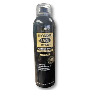 Może przedstawiać: Czarna butelka z klejem w sprayu z napisem "WONDER LACE BOND" i "ADHESIVE SPRAY". Butelka ma przezroczystą nakrętkę i złotą i czarną etykietę. Etykieta zawiera również tekst "EXTREME FIRM HOLD" i "SUPREME".