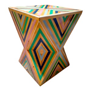 K&ouml;nnte beinhalten: Ein geometrischer Holzhocker mit einem farbenfrohen Streifenmuster. Der Hocker ist aus Holz und in den Farben Gr&uuml;n, Blau, Rosa und Gelb gestrichen.