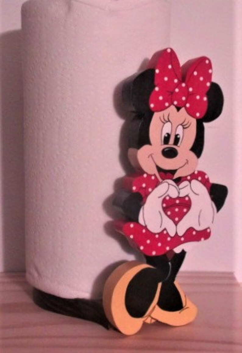 May include: A red and white wooden paper towel holder featuring a cartoon character of Minnie Mouse making a heart shape with her hands.