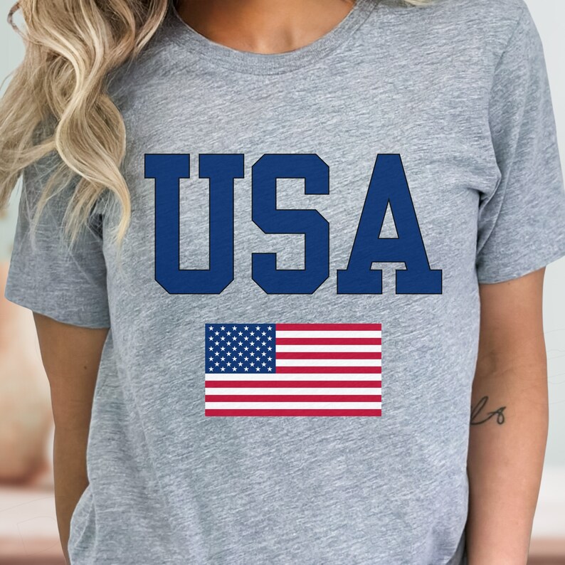 May include: A gray t-shirt with a blue "USA" graphic and an American flag.