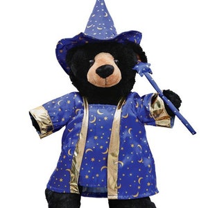 May include: A black plush bear wearing a blue and gold wizard costume with a pointed hat and a star-shaped wand.