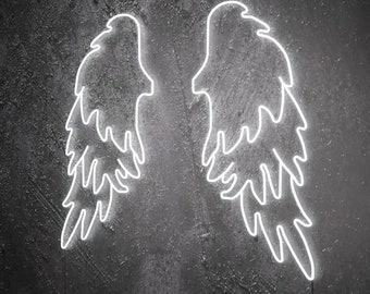 May include: White neon angel wings on a dark gray textured wall. The wings are outlined in white neon and have a feathery design.