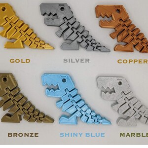 May include: A collection of articulated dinosaur toys in various colors, including gold, silver, copper, bronze, shiny blue, and marble. Each dinosaur has a segmented body and is labeled with its color.