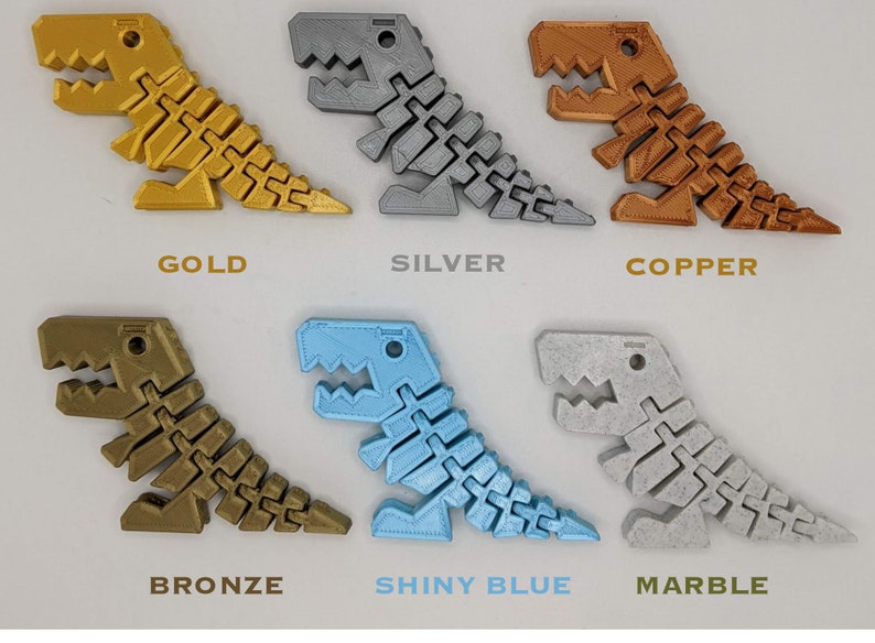 May include: A collection of articulated dinosaur toys in various colors, including gold, silver, copper, bronze, shiny blue, and marble. Each dinosaur has a segmented body and is labeled with its color.