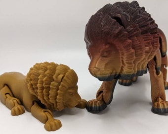 May include: Two articulated lion figurines, one brown and one with a gradient of brown, red, and black. The lions are posed as if they are walking and lying down.