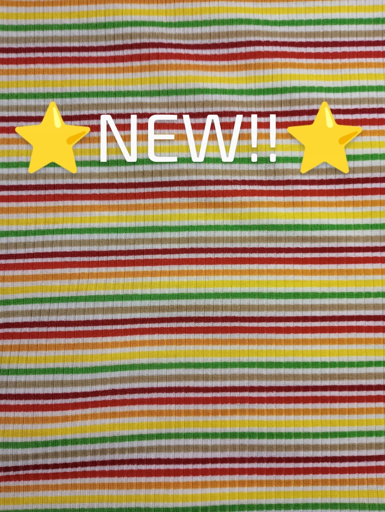 May include: A striped fabric with alternating bands of red, orange, yellow, green, brown, and white. The fabric has a ribbed texture. The words "NEW!!" are printed in white on the fabric.
