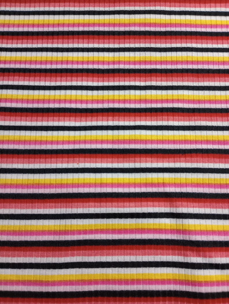 May include: Striped fabric with alternating bands of red, pink, yellow, white and black.