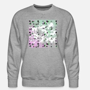May include: A gray sweatshirt with a crew neck. The front features a square pattern of white figures, black and green shapes, and purple and green backgrounds. The design is repeated across the front of the sweatshirt.