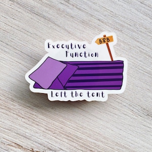 May include: A sticker featuring a purple tent design with the text "Executive Function Left the tent." A signpost indicates "BRB." The tent has purple and black stripes. The sticker is on a light wood grain surface.