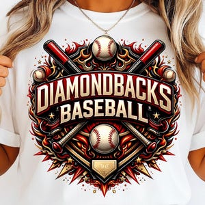 May include: White t-shirt featuring a vibrant graphic design. The design includes the text "DIAMONDBACKS BASEBALL" in gold lettering, baseballs, and crossed bats. The design is set against a red and gold background.