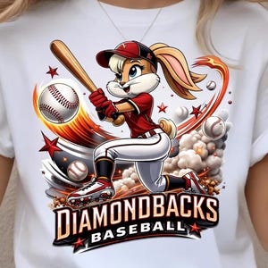 May include: White t-shirt featuring a cartoon bunny in a baseball uniform, swinging a bat. The design includes baseballs, stars, and the text "DIAMONDBACKS BASEBALL" in a bold font. The bunny is wearing a red and black uniform.