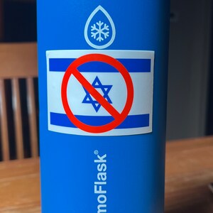 May include: Blue ThermoFlask water bottle with a silver lid. A sticker on the bottle features the Israeli flag with a red prohibition symbol over it. The bottle has a white logo and the words "ThermoFlask" printed on it.