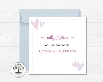 Puede incluir: Una tarjeta blanca con un diseño de corazones rosa y morado. La tarjeta dice "Sally & Steve ¡Están comprometidos! ¡Felicidades!".