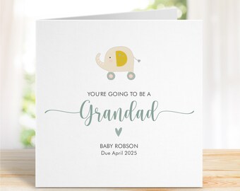Puede incluir: Una tarjeta blanca con una ilustración de elefante azul claro y el texto "You're going to be a Grandad" con un corazón debajo. El texto "Baby Robson Due April 2025" está en la parte inferior de la tarjeta.