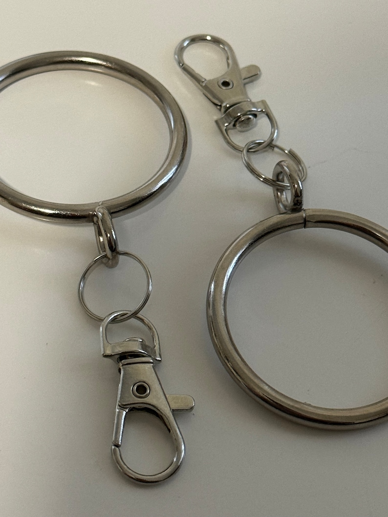 Puede incluir: Dos llaveros plateados con un anillo grande y un anillo m&aacute;s peque&ntilde;o con un cierre de langosta.