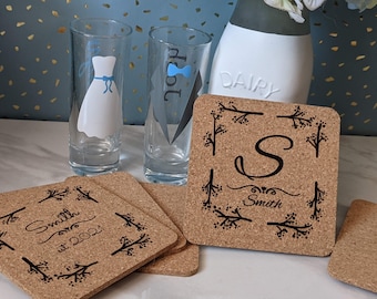 Peut inclure: Ensemble de quatre sous-verres en liège avec des motifs floraux noirs et un texte personnalisé. Un sous-verre présente la lettre "S" et le texte "Smith". Un autre sous-verre présente le texte "Smith est. 2021".