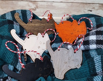 Peut inclure: Quatre ornements de chat en bois de différentes couleurs, dont noir, blanc, gris et marron. Chaque ornement est doté d'une ficelle rouge et blanche pour l'accrocher.