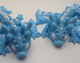 Peut inclure: Quatre figurines en 3D imprimées en bleu et blanc d'une créature mythique au design cristallin et piquant. Les figurines ont des yeux blancs et sont posées dans différentes positions.
