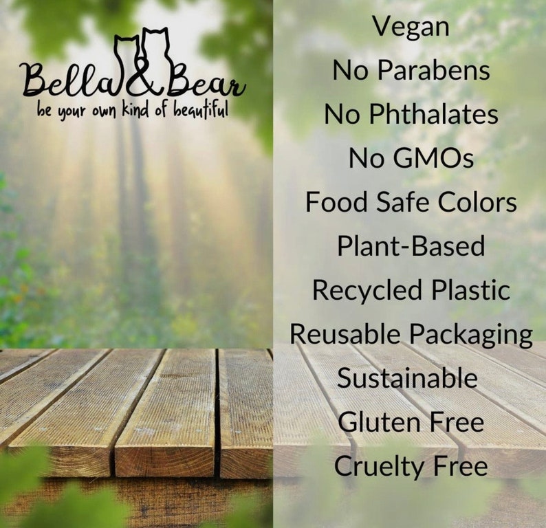 May include: A wooden table with a blurred background of green trees. Text on the right side of the image reads: Vegan, No Parabens, No Phthalates, No GMOs, Food Safe Colors, Plant-Based, Recycled Plastic, Reusable Packaging, Sustainable, Gluten Free, Cruelty Free.