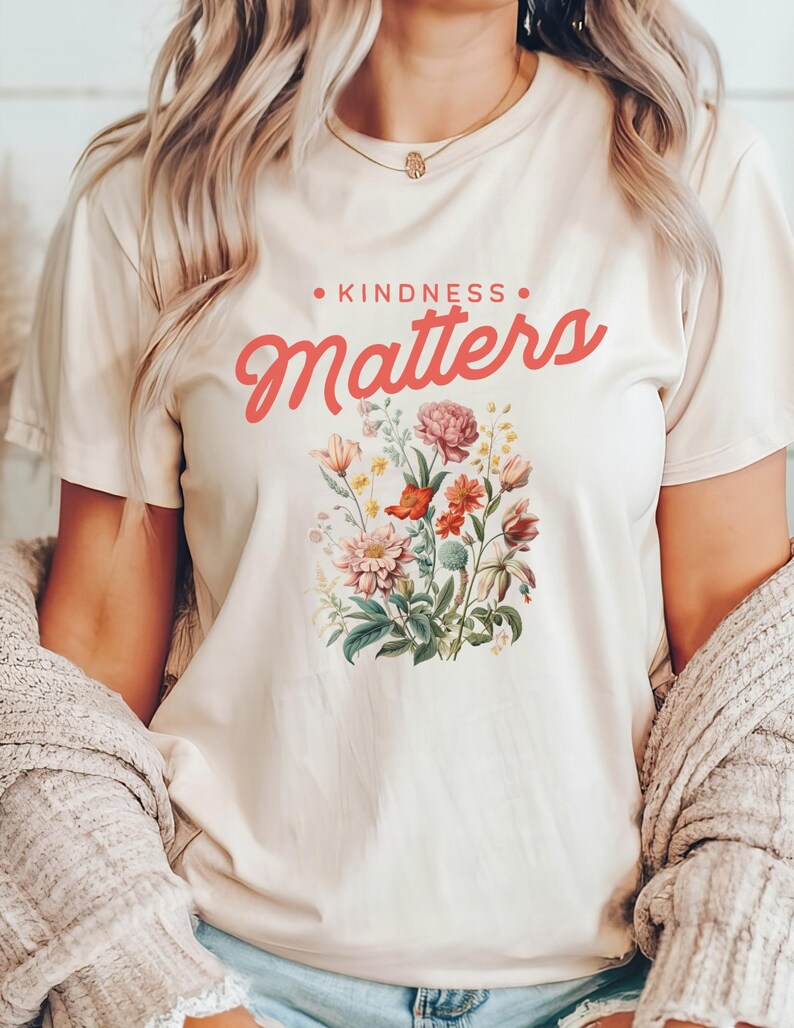 May include: A white t-shirt with a floral design and the text "KINDNESS MATTERS" in pink lettering.