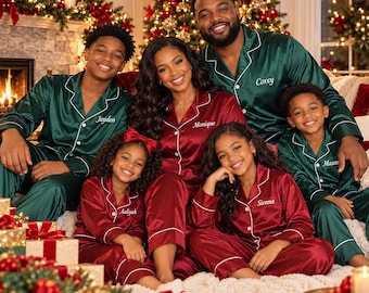 May include: A group wearing matching satin pajama sets in deep green and dark red with white piping. The shirts feature button-down fronts and embroidered names including Jayden, Monique, Corey, Aaliyah, Sienna, and Mason. The fabric has a smooth, reflective finish.