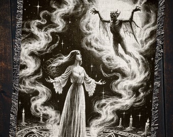 Op de afbeelding: Een zwart-wit tapijt met een vrouw in een lange witte jurk die op een pentagram staat met een demonische figuur op de achtergrond.