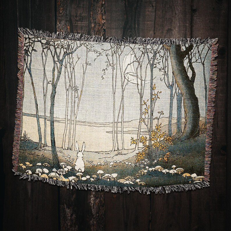May include: A tapestry depicting a white rabbit standing in a forest with a moon in the sky. The forest is made up of tall, thin trees with a river in the background. The rabbit is surrounded by small, white mushrooms.