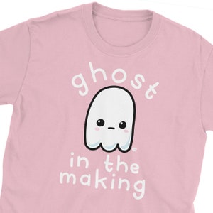 May include: Pink t-shirt with a white ghost illustration and the text "ghost in the making".
