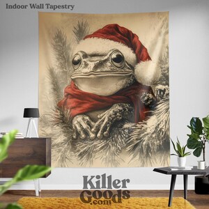 May include: A Christmas-themed tapestry featuring a frog wearing a red Santa hat and scarf. The frog is sitting in a snowy forest setting.