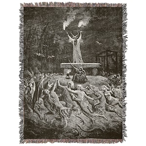May include: Black and white woven tapestry featuring a scene of a devilish figure with horns and a long robe, standing on a platform and raising their arms with torches.  The devilish figure is surrounded by a crowd of people running towards them.