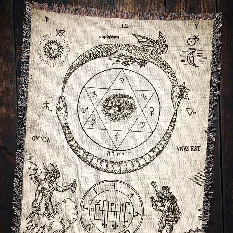 Puede incluir: Un tapiz con una ilustraci&oacute;n en blanco y negro de una serpiente mordi&eacute;ndose la cola, formando un c&iacute;rculo alrededor de una estrella de seis puntas con un ojo en el centro. El texto "OMNIA", "VNVS EST", "III", "&omicron;&upsilon;&rho;ά&beta;ό&rho;&omicron;&sigmaf;", "יהוה", y "Z" tambi&eacute;n se incluyen en el dise&ntilde;o.