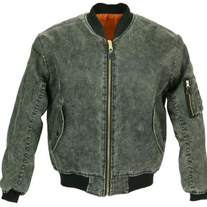 Peut inclure: Une veste bomber en denim gris foncé avec un col, des poignets et une ceinture côtelés noirs. La veste a une fermeture éclair dorée et une poche zippée sur la manche droite.