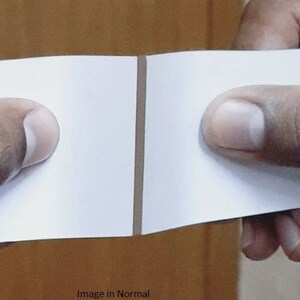 May include: A close-up of a white piece of paper folded in half. The paper is held by two hands, with the crease in the middle of the paper. The text "Image in Normal Mirror" is visible at the bottom of the image.