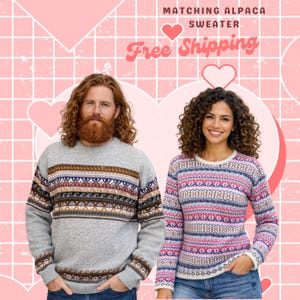 May include: Two people wearing matching alpaca sweaters. The man's sweater is gray with brown, blue, and white patterns. The woman's sweater is pink, blue, and white with a similar design. The background is pink with heart shapes.
