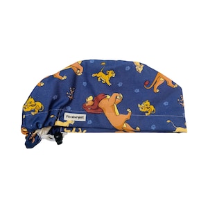May include: Blue surgical scrub hat with a print of lions from the movie The Lion King. The hat has a white label that says "PittsburghPE".