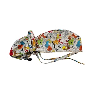 May include: A white surgical scrub hat with a colorful cartoon print of various characters. The hat has a tie on the back and the text "PittsburghPE" is printed on the side.