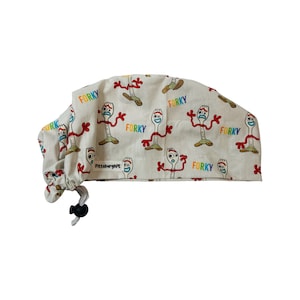 May include: A white scrub hat with a repeating pattern of the character Forky from the Toy Story movie. The hat has a drawstring with a black toggle. The text "FORKY" is repeated in rainbow colors on the hat.