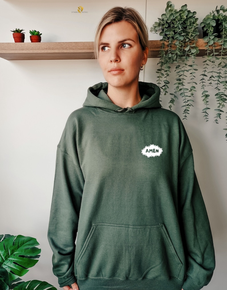 May include: A dark green hooded sweatshirt with a white cloud-shaped graphic that says "AMEN" in all caps.