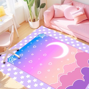 May include: A pink, purple, and blue rug with a white crescent moon and clouds. The rug has a white background with a pattern of small white flowers.