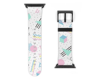 May include: A white Apple Watch band with a geometric pattern in pink, blue, and green. The band is made of silicone and has a black buckle.